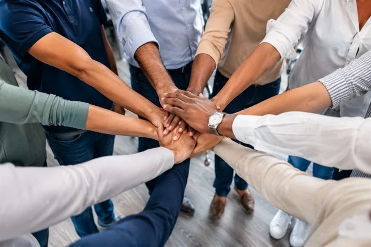 Mains réunies au centre d'une équipe — cohésion d'équipe